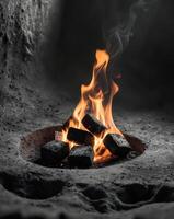 Glowing Embers of Burning Charcoal Briquettes in a Clay Pit photo