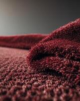 a close up of a textured deep red carpet showcasing its plush fibers photo