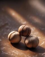 A close up of three hazelnuts on a brown surface photo