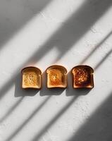 Three slices of toast showing different levels of browning photo