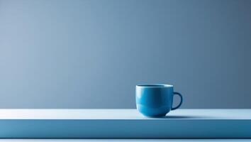 there is a blue cup sitting on a table with a blue background photo
