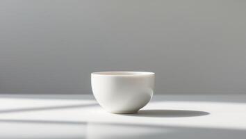 there is a white cup sitting on a table with a shadow photo