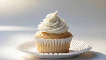 A cupcake with white frosting on top on a white plate photo