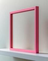 a close up of a pink square frame on a shelf photo
