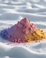 a close up of a pile of colored powder on a white surface photo
