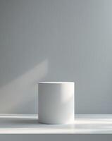 a white pedestal on a gray background with a light photo