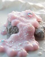 A pink liquid is sitting on a rock photo