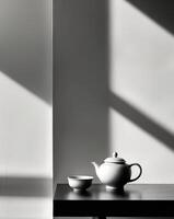 there is a tea pot and cup on a table next to a window photo