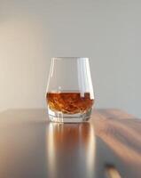 there is a glass of whiskey sitting on a table photo