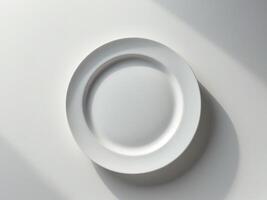 A white plate on a table with shadow photo