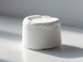 A marshmallow sitting on top of a white surface photo