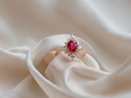 Elegant Ruby Ring with Diamonds on Soft Fabric Background photo