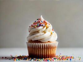 A cupcake with white frosting and sprinkles photo