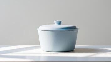 A blue container sitting on a table in front of a window photo