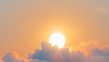 The sun is setting behind a cloud covered sky photo