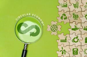 Circular economy icon on green background magnifying glass in circular economy concept for future business growth and renewable material resources. Sustainable environment. photo