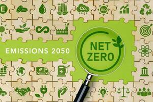 net zero and carbon neutral The green net zero icon on the Jigsaw and the net zero symbol on the magnifying glass. Ideas for a net-zero greenhouse gas emissions target Long term photo