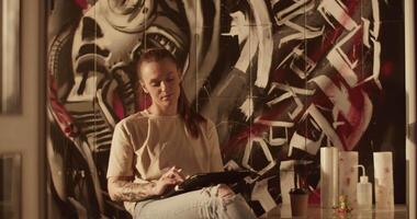 Skilled female tattooist creating new picture using graphic table video