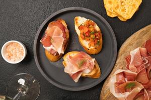 Tasty bruschetta served with wine on gray background photo