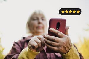 Customer Experience Concept. Excellent. Happy senior woman pressing face emoticon on virtual touch screen at smartphone .Customer service evaluation concept. photo