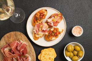 Tasty bruschetta served with wine on gray background photo