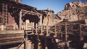 Old wooden structures in a rustic settlement near rocky cliffs during daylight video