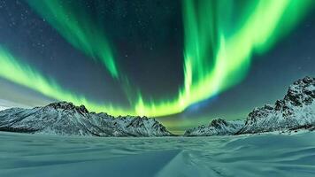Stunning view of the aurora borealis over a snowy mountain range in the arctic. video