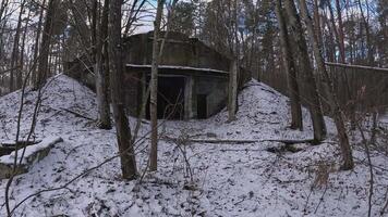 In an eerie, abandoned bunker located in a desolate snowy landscape, it is nestled peacefully among trees video