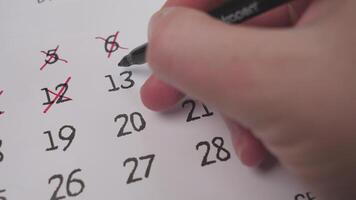 A closeup of a hand marking a date on a calendar, highlighting effective organization and time management video
