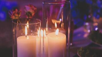 Beautiful candle scene with warm bokeh and white flowers for peaceful ambiance. An elegant candle scene with delicate white flowers and a soft, calming background. video
