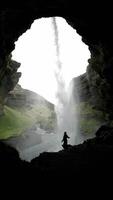 Waterfall in Iceland Viewed from Inside a Cave with Silhouetted Figure video