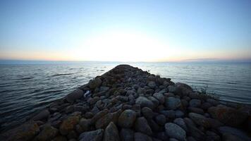 Rocky Jetty Extending into Calm Waters at Dusk or Dawn video