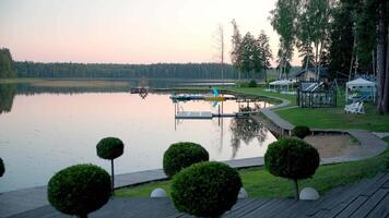 Lakeside Dock with Boats and Forest at Dawn or Dusk video