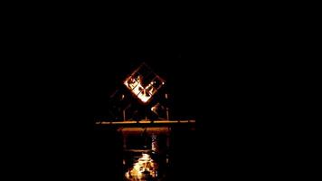 Solitary Lantern in Geometric Wooden Structure Reflecting on Water video