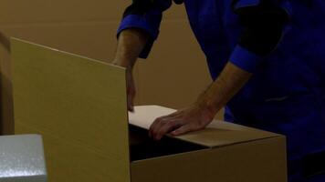 Person in Uniform Assembling Cardboard Box in Warehouse Setting video