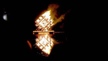 Nighttime View of Geometric Structure on Fire Over Water video