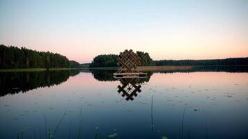 Calm Lake with Floating Wooden Structure and Dense Forest Border video