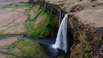 Seljalandsfoss Waterfall with Pathways and Rolling Hills in Iceland video