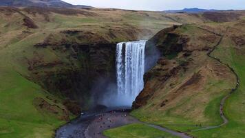 Skogafoss Waterfall with Visitors on Path in Icelandic Landscape video