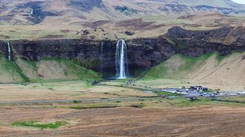Seljalandsfoss Waterfall with Visitors and Rolling Hills in Iceland video