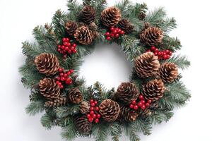 Holiday wreath decorated with pinecones and berries on white background photo