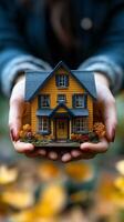 Small model house held in hands, symbolizing dreams of home ownership and comfort photo