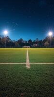 Nighttime view of a well-lit soccer field with bright stadium lights and clear sky photo