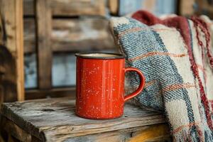 Red mug on wooden table in cozy cabin during winter afternoon photo
