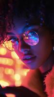 Young woman gazes at phone screen during evening in soft, warm light photo