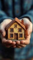 Small model house held in hands, symbolizing dreams of home ownership and comfort photo