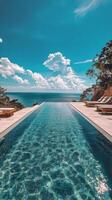 Beautiful infinity pool overlooking the ocean under a clear sky with palm trees photo