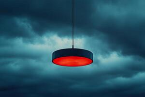 Red industrial light hanging against a moody sky at twilight photo