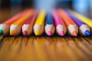 Colorful pencils arranged in a straight line on a wooden surface for creative activities photo
