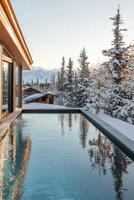 Luxurious winter retreat with a serene swimming pool surrounded by snow-covered trees photo
